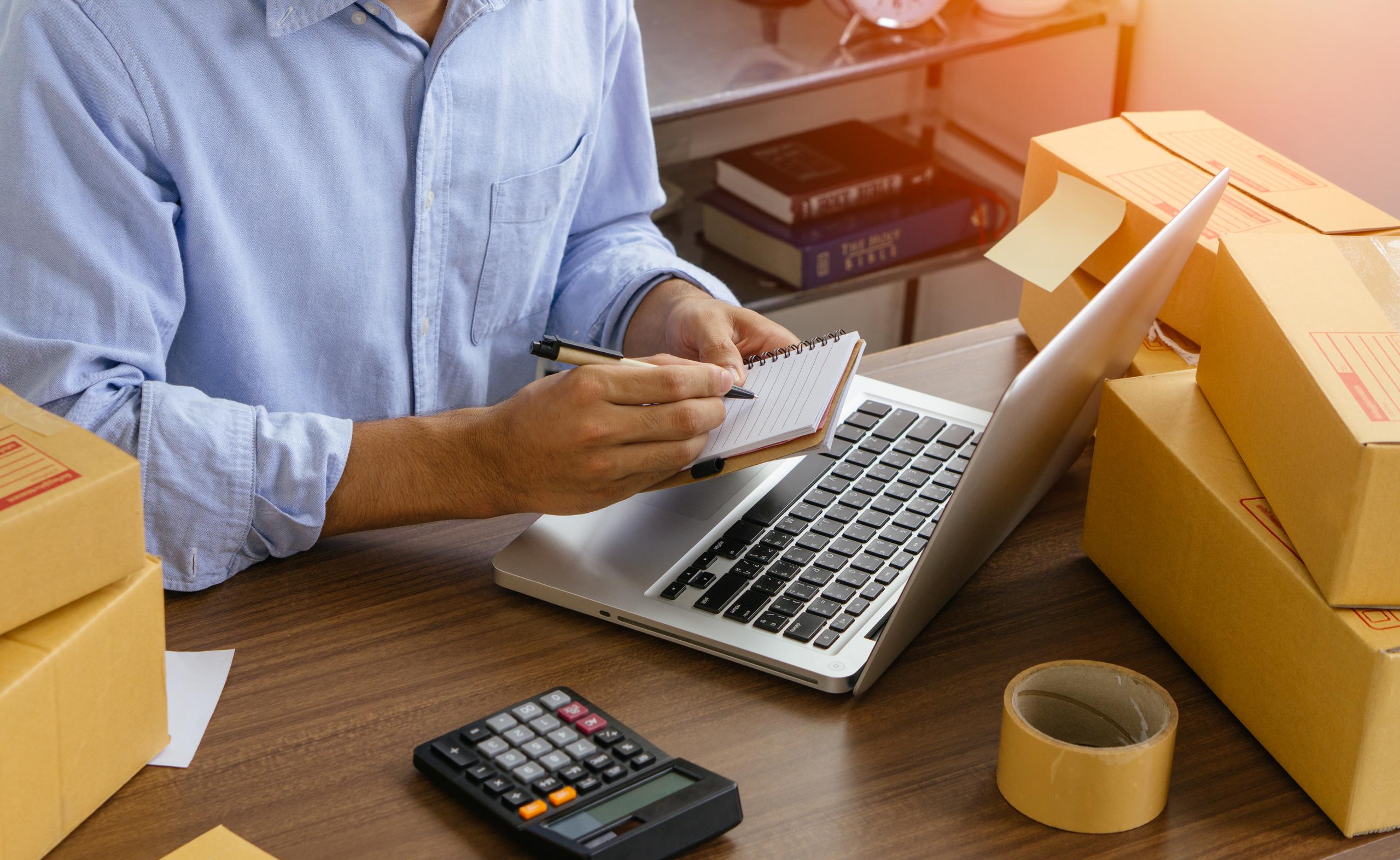 Comerciante con una libreta y un portátil preparándose para crear su tienda online en jShop.