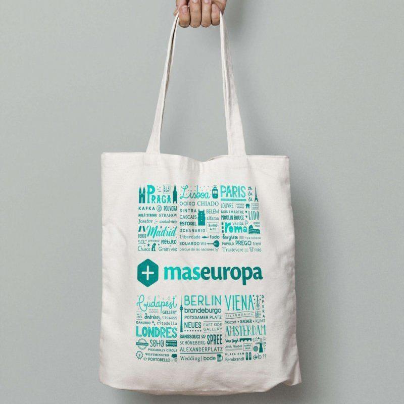 Bolsa de tela blanca con diseño verde y nombres de ciudades europeas.
